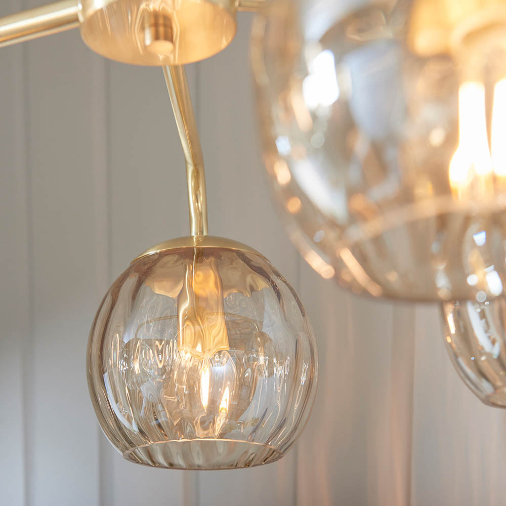 Close-up of a gold and glass pendant light fixture. Endon Dimple 5 light Pendant Light in Brushed Gold 91969